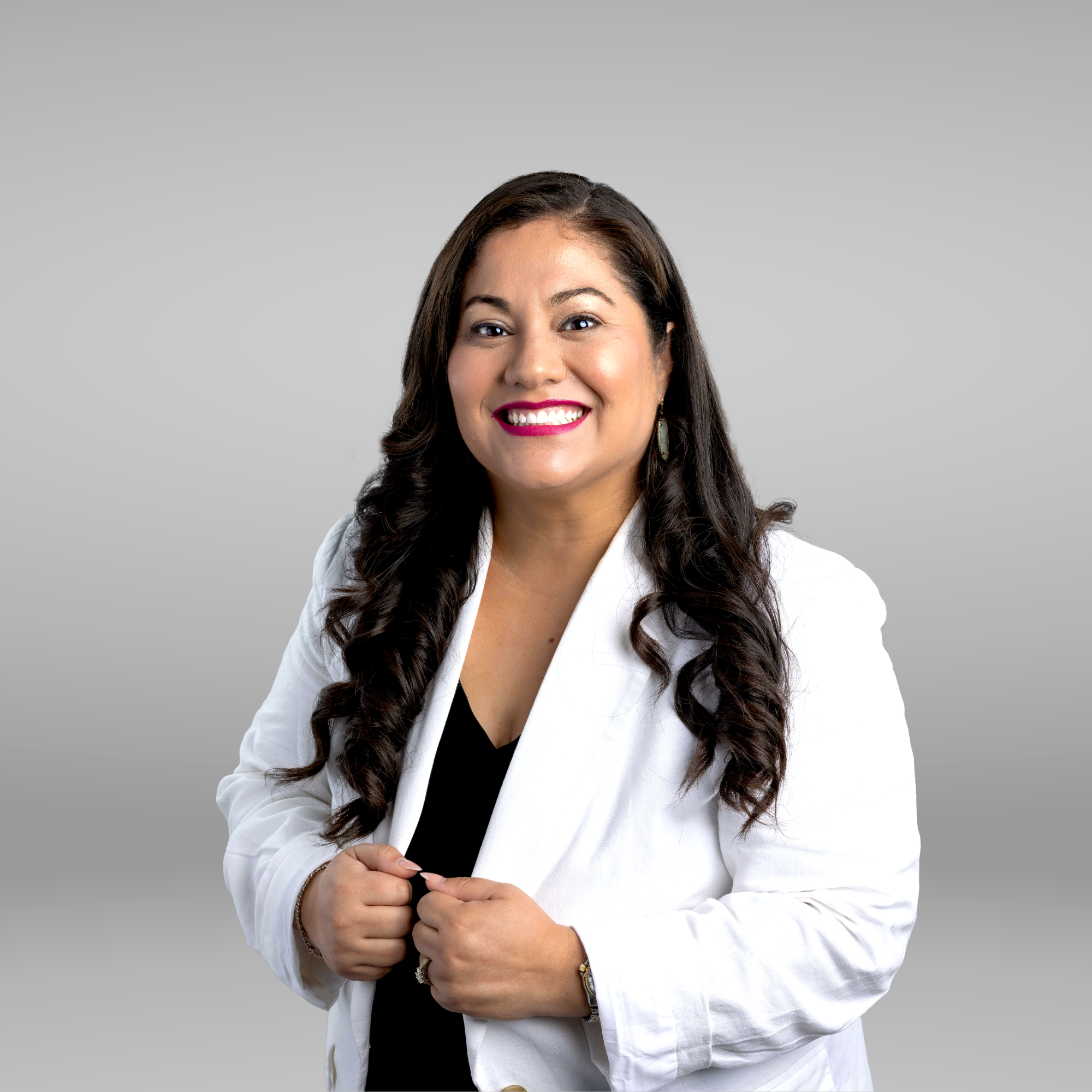 Rose Lazo smiling in a white blazer, with her hands visible